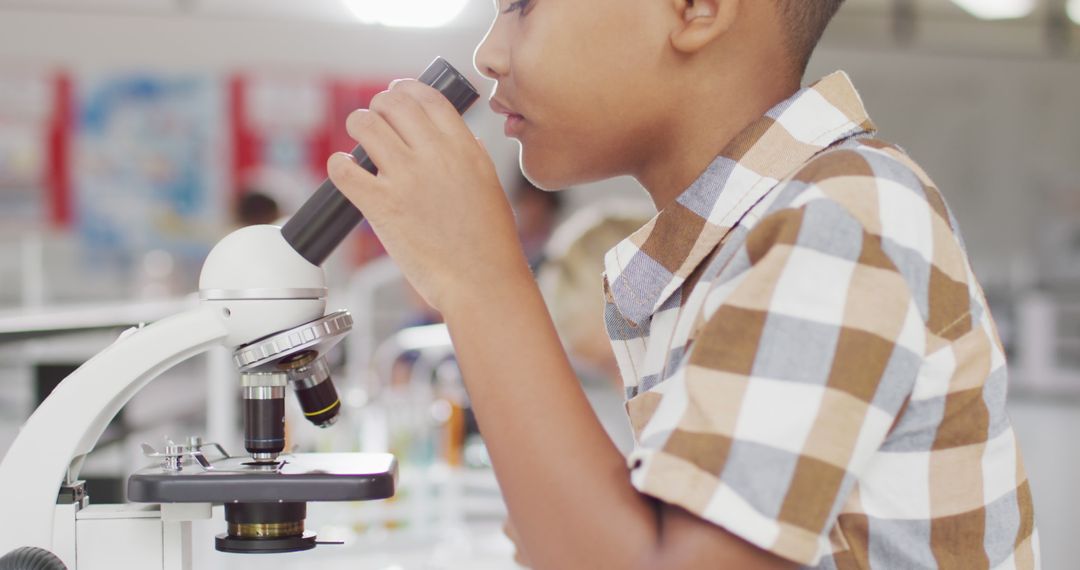 Young Student Examining Microscope in Science Class