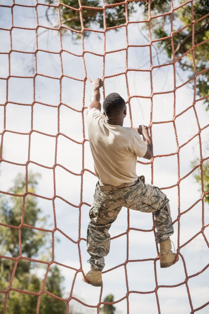Military soldier climbing net during obstacle course - Free Images, Stock Photos and Pictures on Pikwizard.com