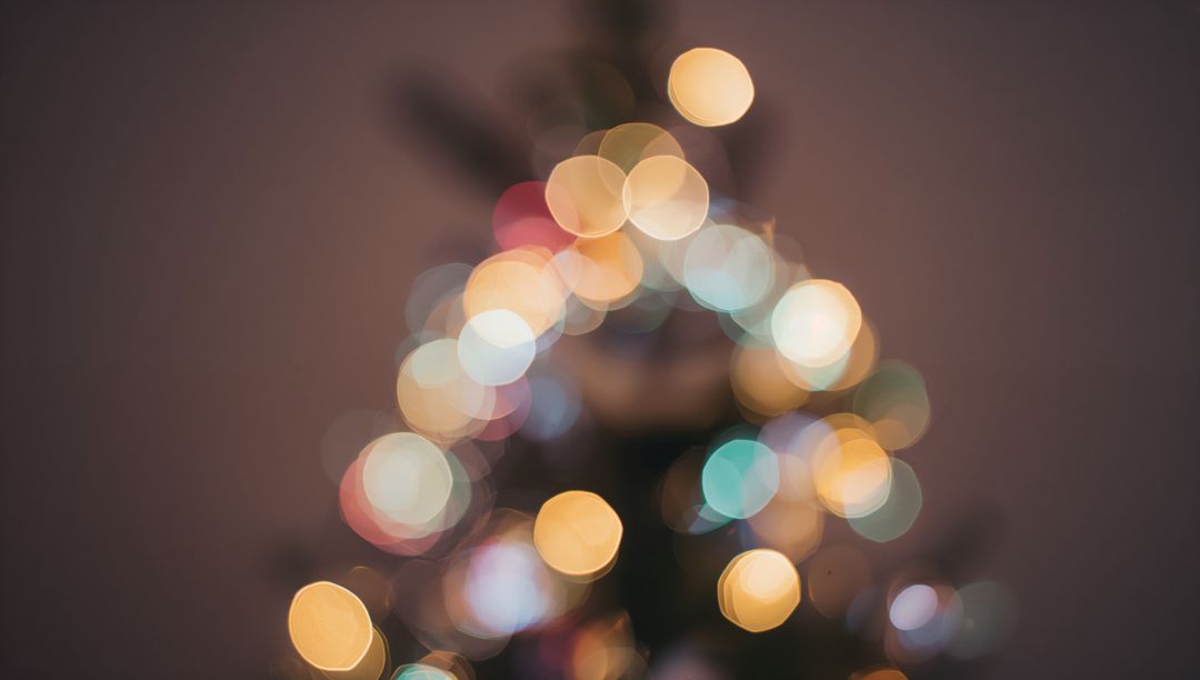 Glowing bokeh Christmas tree lights creating cozy festive blur with multicolor warm glow