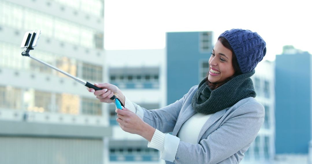 Cheerful Woman Taking Selfie with Selfie Stick Outdoors - Free Images, Stock Photos and Pictures on Pikwizard.com