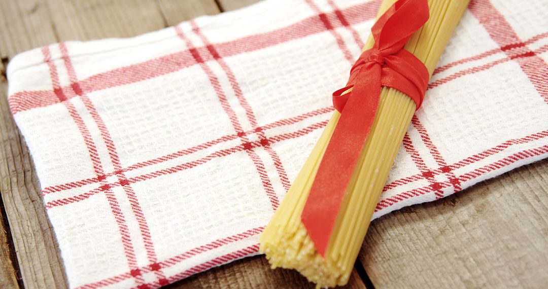 Bunch of Uncooked Spaghetti Tied with Red Ribbon on Checkered Cloth - Free Images, Stock Photos and Pictures on Pikwizard.com