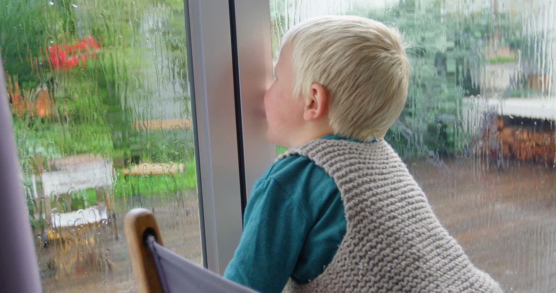 Child Looking Through Rainy Window in Cozy Home Setting
