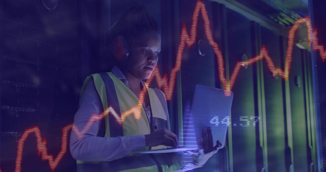 Data Center Technician Monitoring Servers with Laptop and Performance Graph Overlay