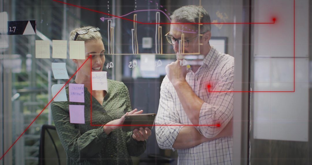 Business Professionals Analyzing Data on Glass in Modern Office