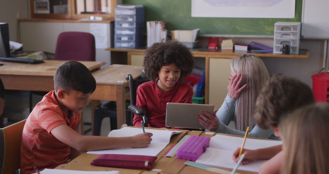 Children Engaging with Teacher Using Tablet in Classroom Setting