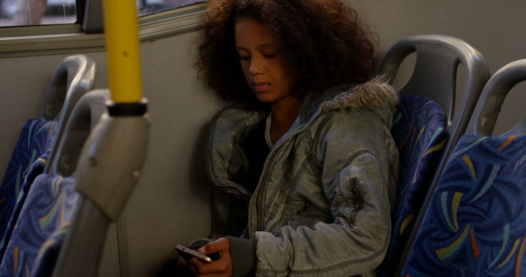 African american girl sitting in city bus using smartphone - Free Images, Stock Photos and Pictures on Pikwizard.com