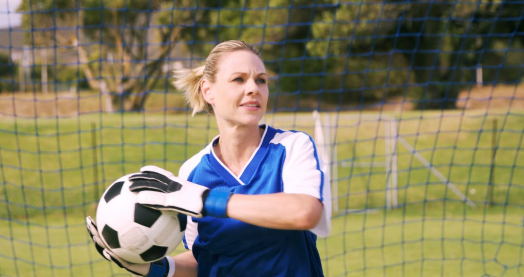 Woman Goalkeeper in Action Holding Soccer Ball on Field - Free Images, Stock Photos and Pictures on Pikwizard.com