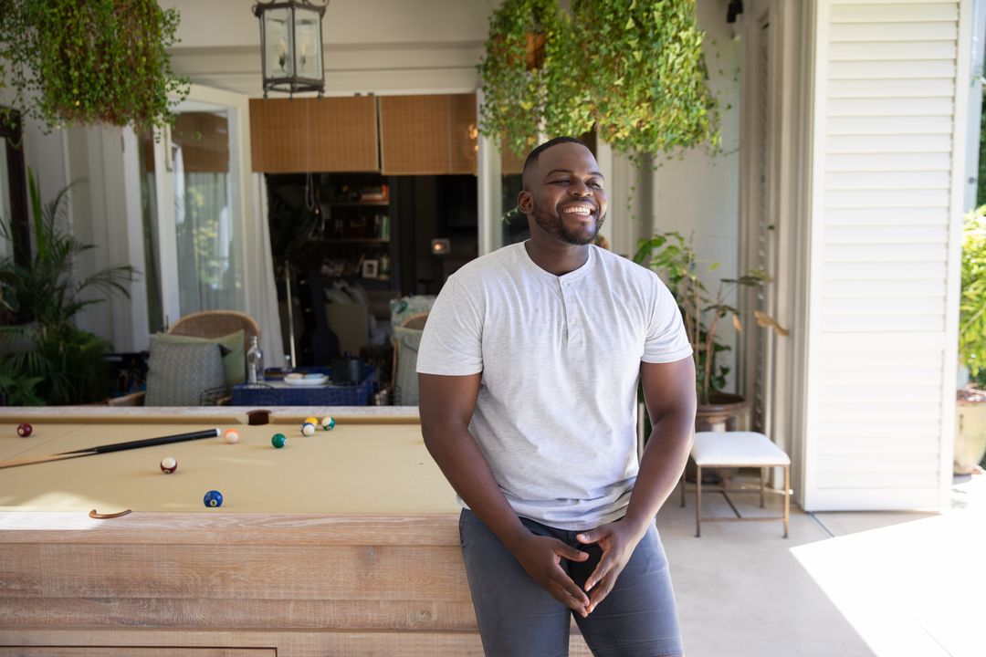 Man Relaxing on Veranda with Billiards Table Surrounded by Greenery