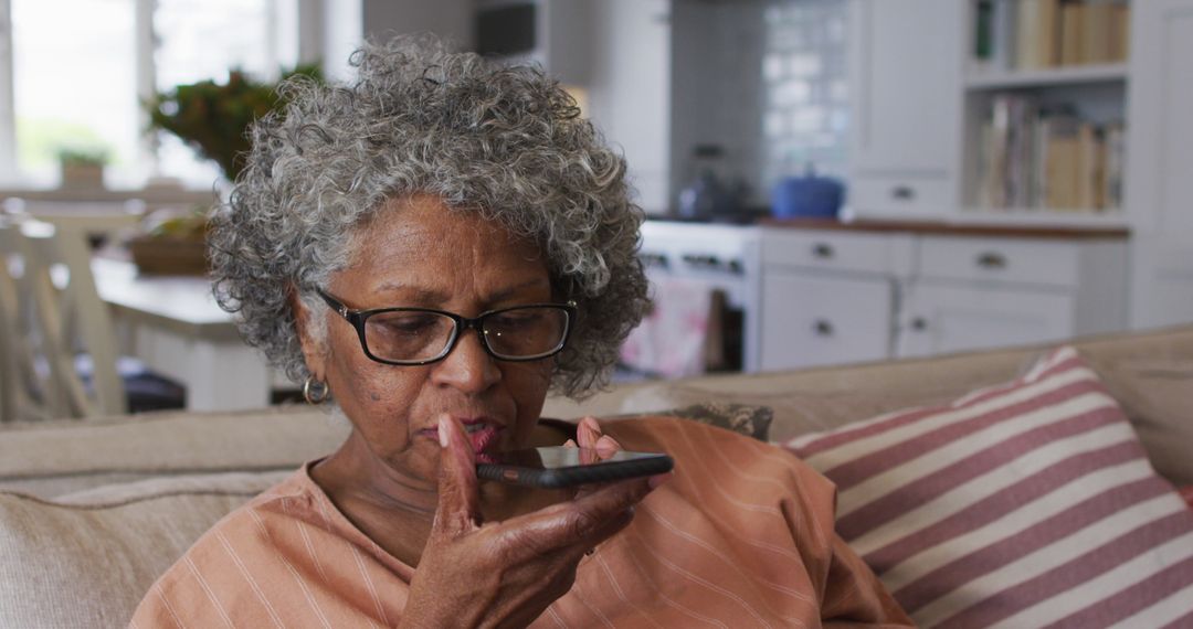 Elderly Woman Using Voice Assistant on Smartphone in Modern Home - Free Images, Stock Photos and Pictures on Pikwizard.com