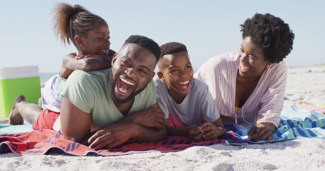 Happy African American Family Relaxing on Beach Blankets and Laughing Together - Free Images, Stock Photos and Pictures on Pikwizard.com