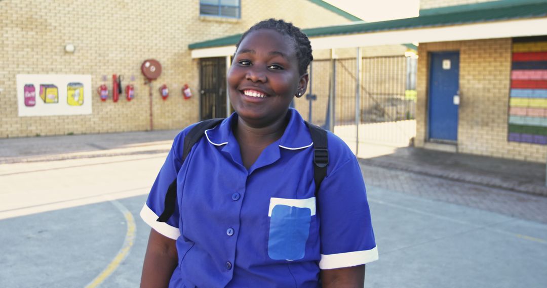 Smiling African American Schoolgirl in Uniform Outside School