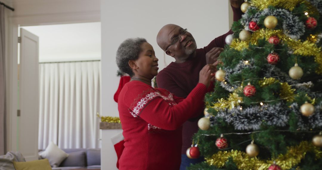 Happy senior african american couple decorating christmas tree in the living room - Free Images, Stock Photos and Pictures on Pikwizard.com