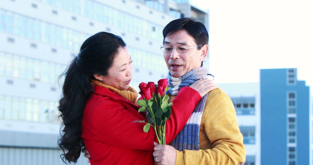 Happy Asian Couple Embracing with Red Rose Bouquet Outside - Free Images, Stock Photos and Pictures on Pikwizard.com