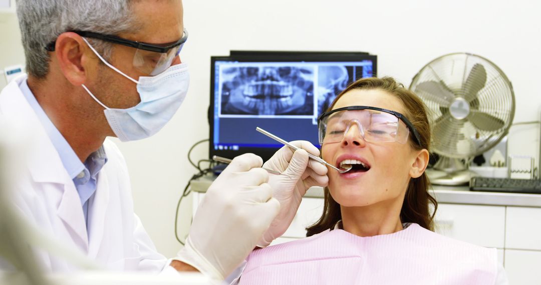 Dentist Examining Female Patient's Teeth Using Dental Tools in Clinic - Free Images, Stock Photos and Pictures on Pikwizard.com