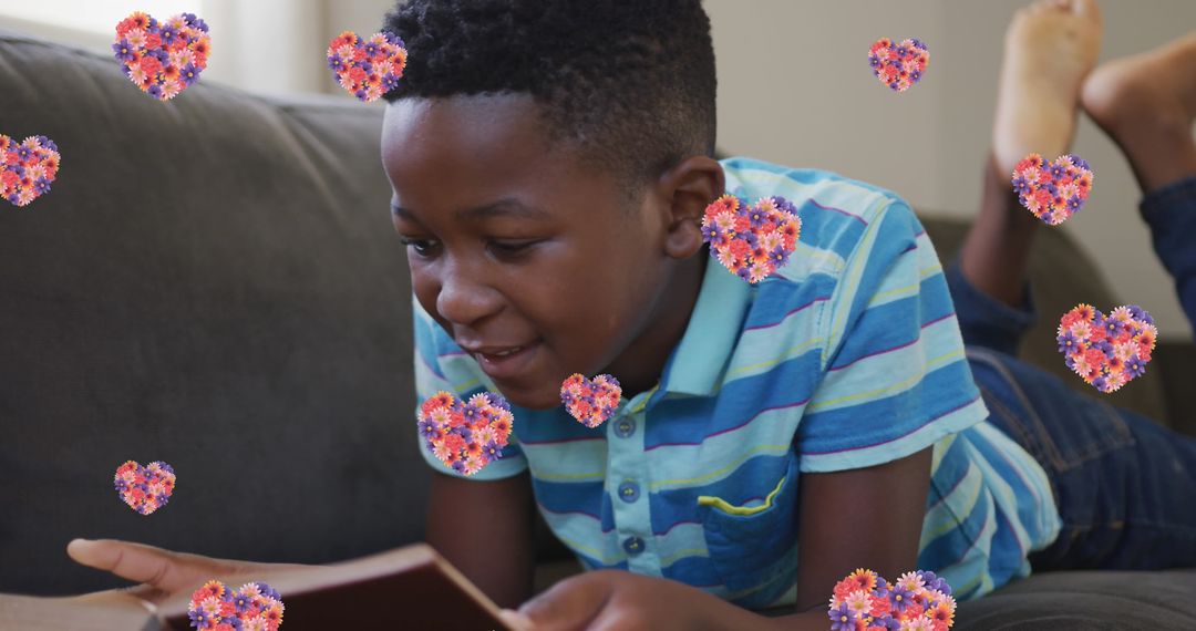 Smiling Boy Enjoys Reading Book with Floral Hearts