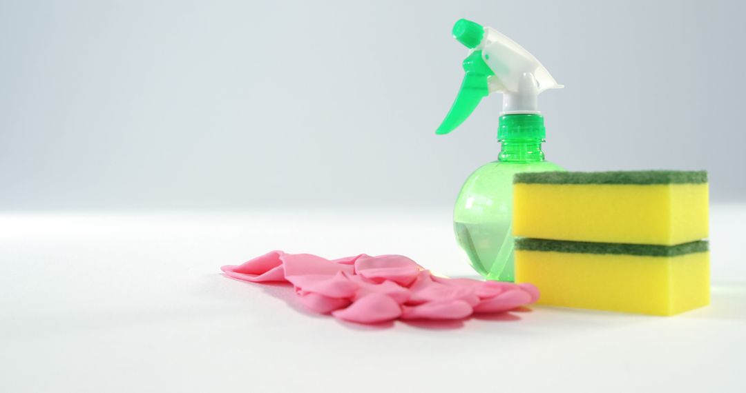 Cleaning Supplies Including Spray Bottle, Sponge, and Pink Gloves on White Surface - Free Images, Stock Photos and Pictures on Pikwizard.com