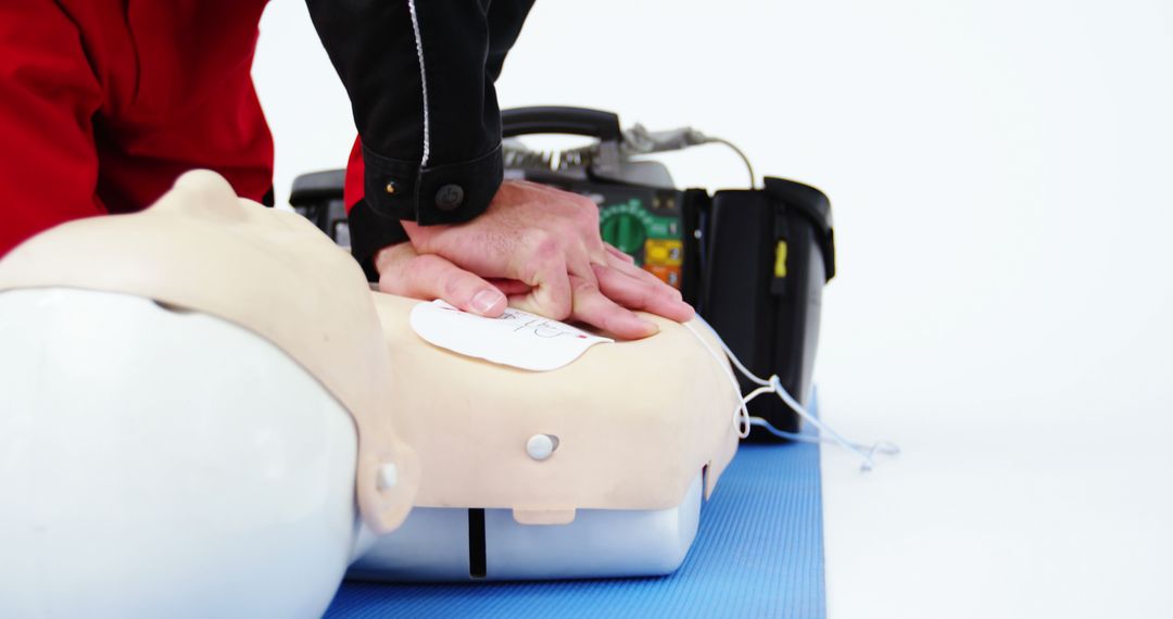 Hands Performing CPR on Dummy with AED In Background - Free Images, Stock Photos and Pictures on Pikwizard.com