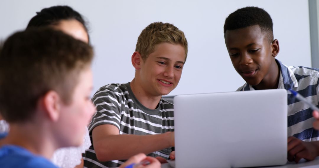 Teen Boys Collaborating on Laptop with Focus and Teamwork