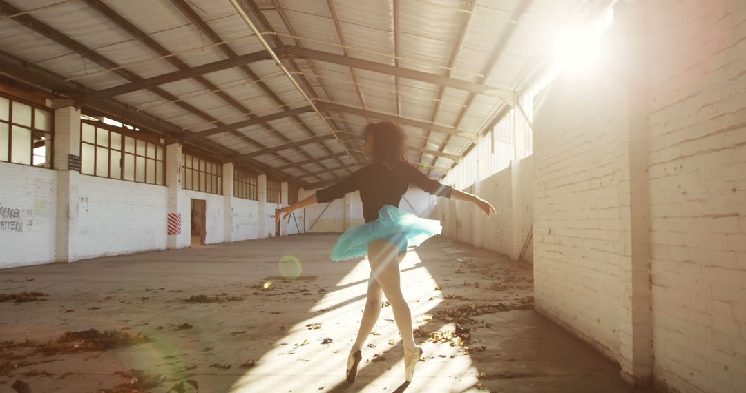 Ballet Dancer Performing in Sunlit Industrial Warehouse