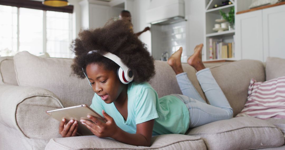 Young Girl Relaxing on Couch Listening to Music and Using Tablet - Free Images, Stock Photos and Pictures on Pikwizard.com