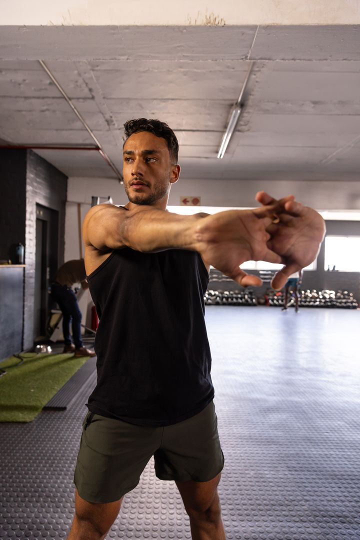 Man Stretching in Industrial Style Gym Enhancing Flexibility