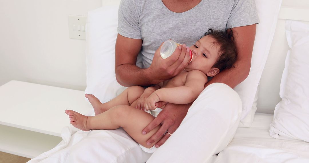 Father Feeding Baby With Bottle in Comfortable Home Setting