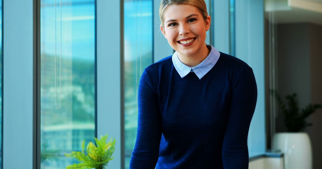 Smiling Woman in Office with Blue Sweater and Collared Shirt - Free Images, Stock Photos and Pictures on Pikwizard.com