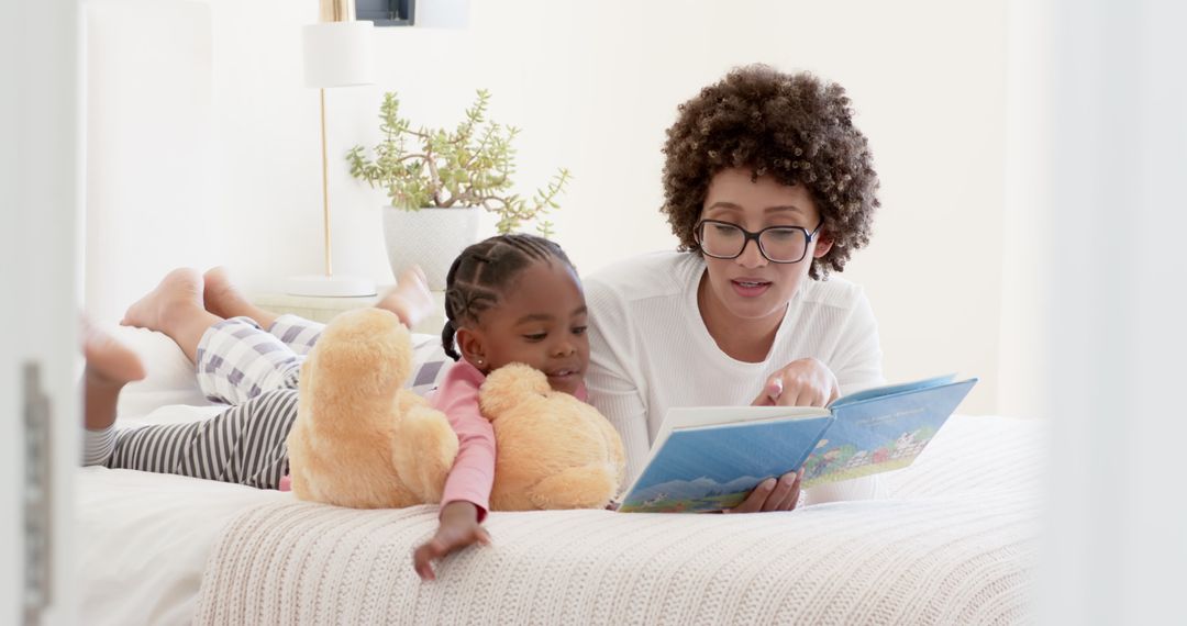 Mother and Daughter Reading Book Together with Teddy Bear at Home