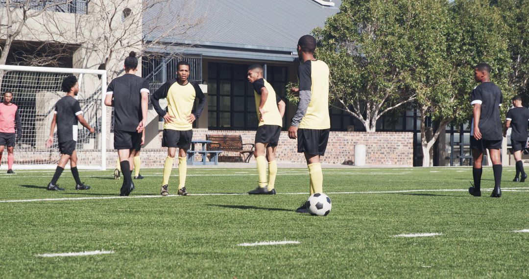 Youth Soccer Team Practicing on School Field under Sunny Sky