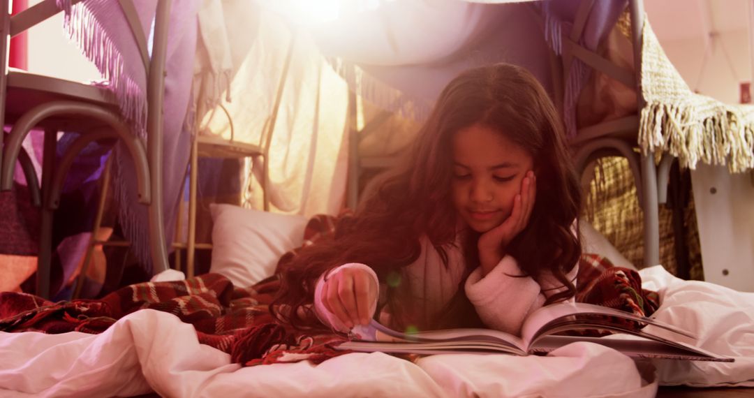 Young Girl Reading Book in Blanket Fort with Sunlight Shining Through - Free Images, Stock Photos and Pictures on Pikwizard.com