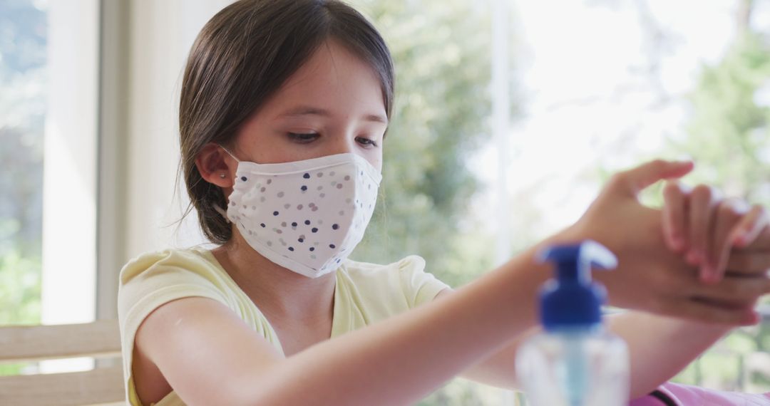 Young Girl Wearing Face Mask Using Hand Sanitizer at Home - Free Images, Stock Photos and Pictures on Pikwizard.com