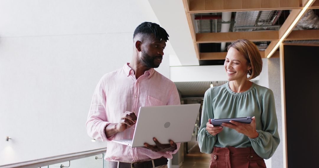 Professionals Collaborating in Modern Office with Laptop and Tablet