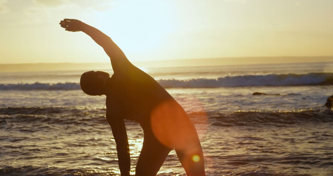 Person stretching at beach during sunrise - Free Images, Stock Photos and Pictures on Pikwizard.com