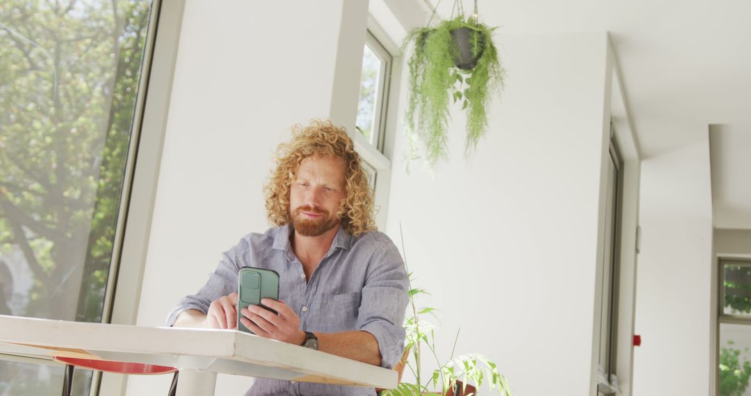 Caucasian Man Relaxing in Cafe Using Smartphone