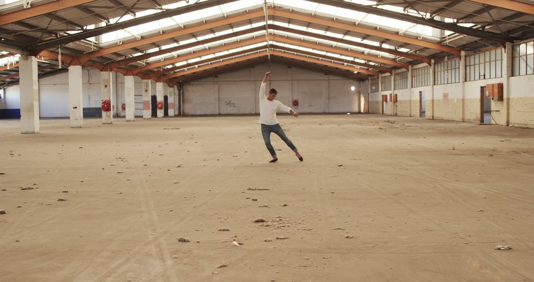 Caucasian Dancer Moving Expressively in Spacious Warehouse