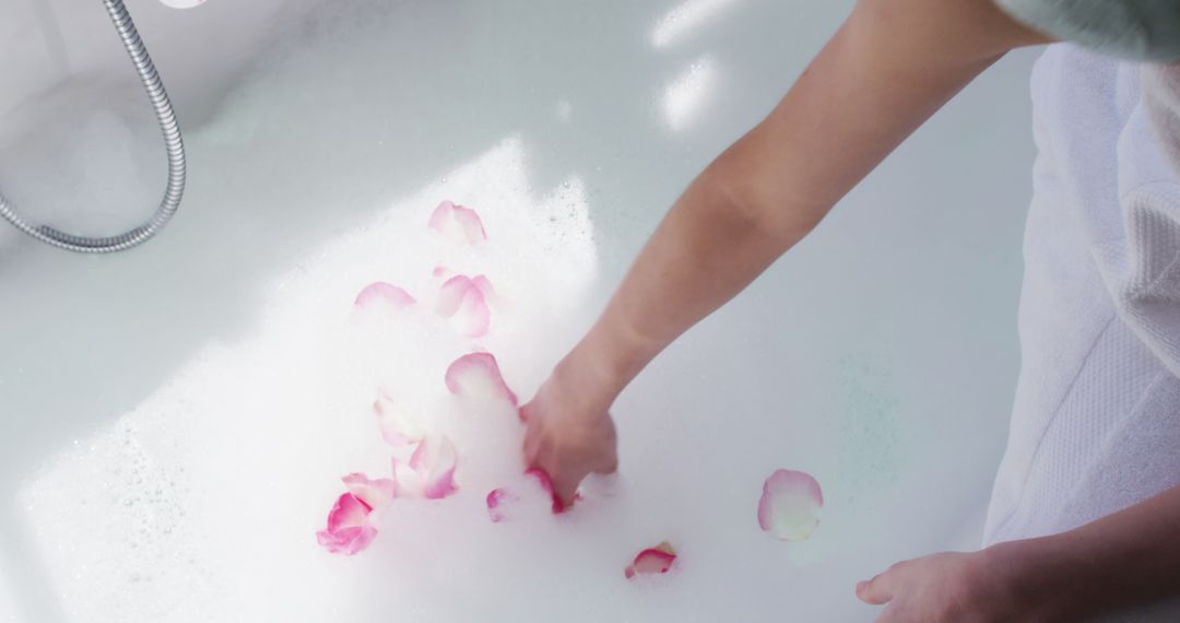 Hand Placing Rose Petals in Bubble Bath for Spa Relaxation - Free Images, Stock Photos and Pictures on Pikwizard.com