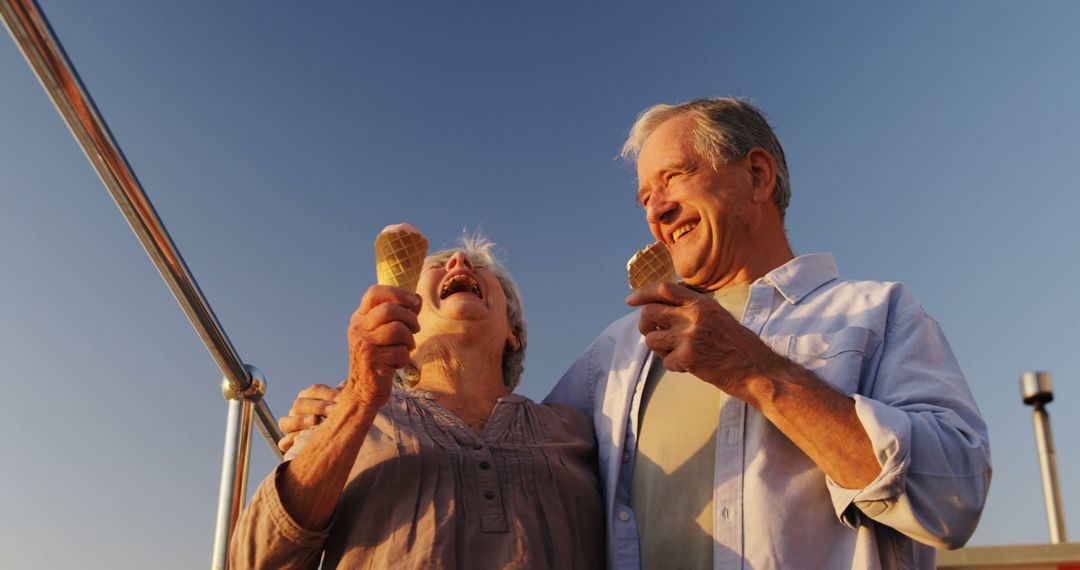 Joyful Senior Couple Enjoying Ice Cream at Waterfront