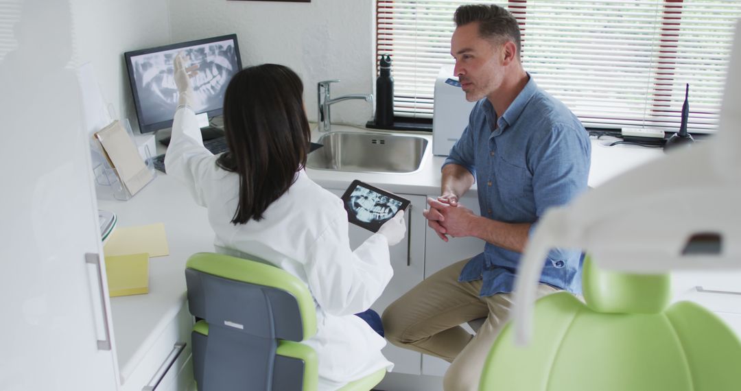 Dentist Consulting Male Patient with Modern Technology - Free Images, Stock Photos and Pictures on Pikwizard.com