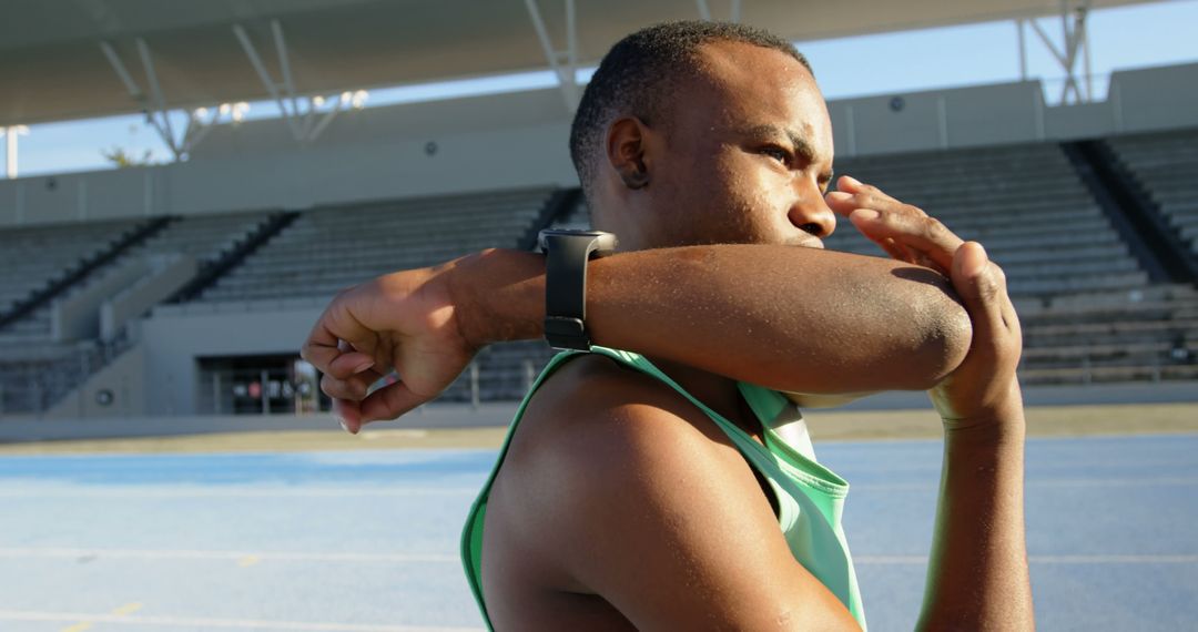 Male Athlete Stretching Arm on Outdoor Track - Free Images, Stock Photos and Pictures on Pikwizard.com