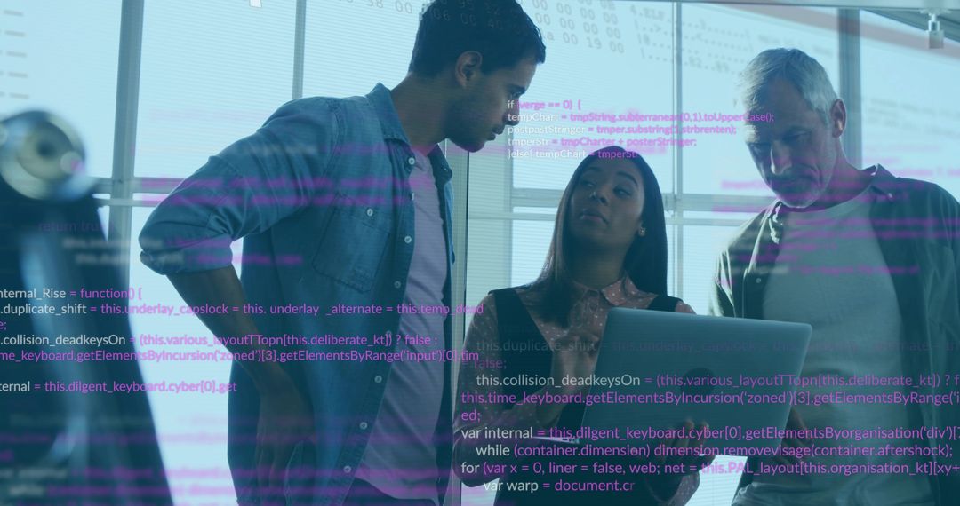 Software team examining code on laptop leaning over workstation in bright glass office