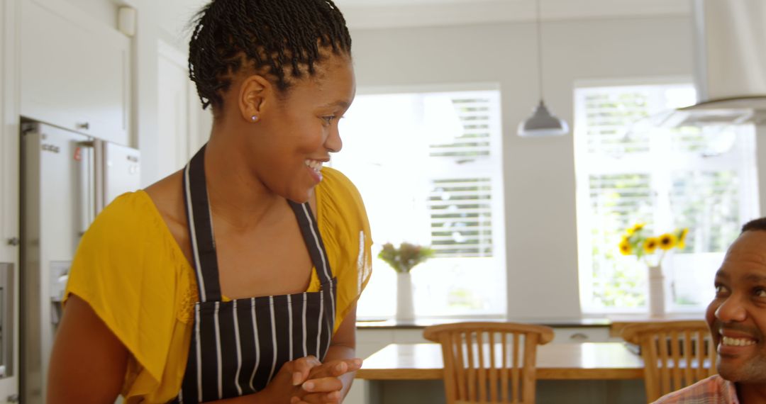 Smiling Woman in Kitchen Interacting with Family Member - Free Images, Stock Photos and Pictures on Pikwizard.com