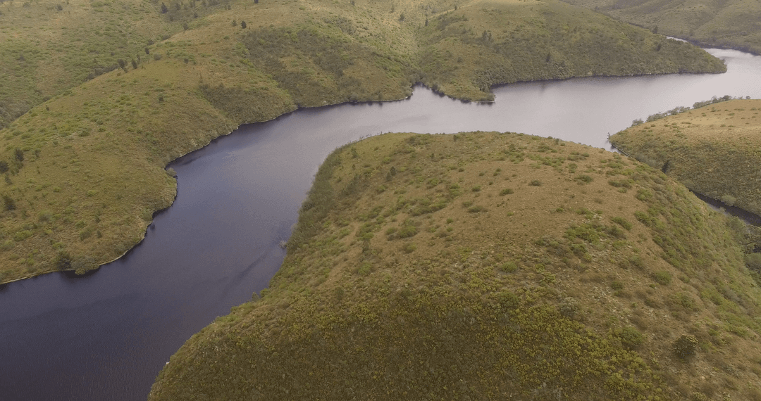 High Angle Transparent River Meandering through Verdant Hills