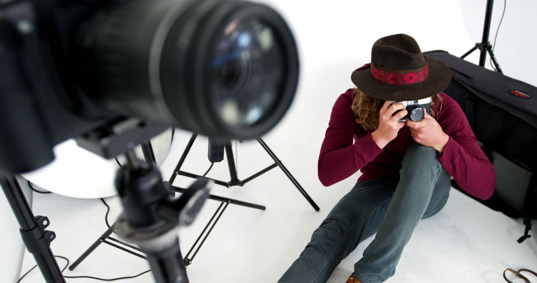 A casually dressed Caucasian photographer shoots in a studio with space for text on the left. - Free Images, Stock Photos and Pictures on Pikwizard.com