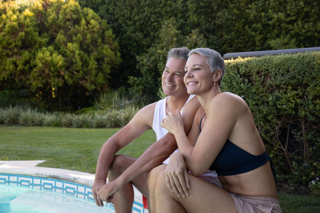 Senior Couple Relaxing by Poolside in Sunny Backyard