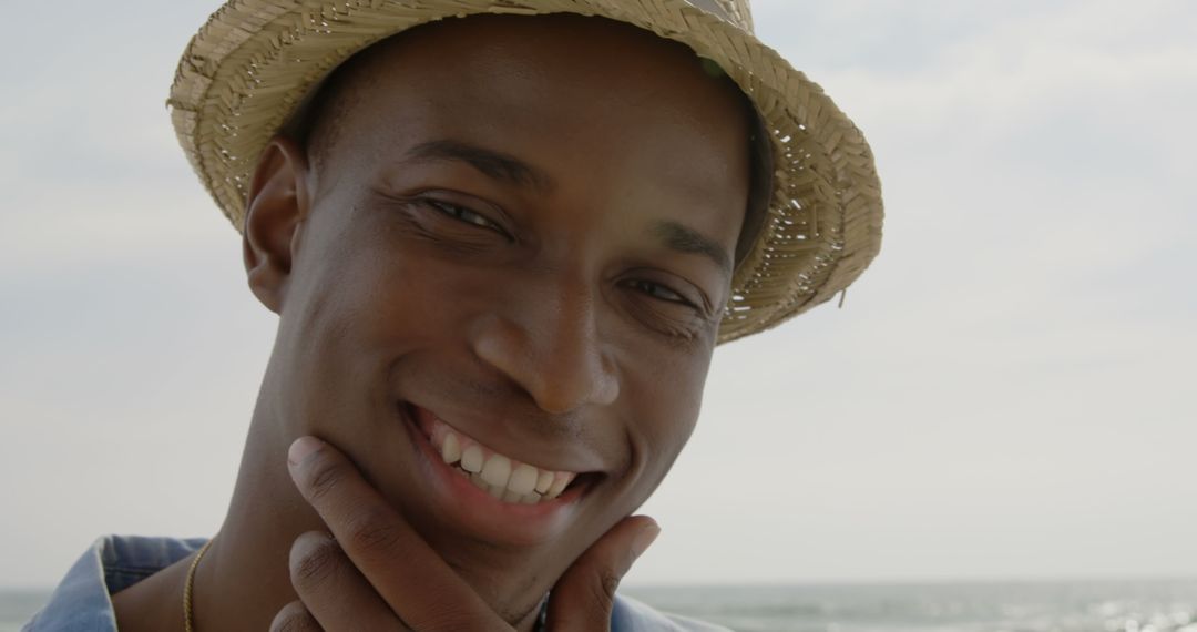 Close-Up of Smiling Man Wearing Straw Hat at Beach
