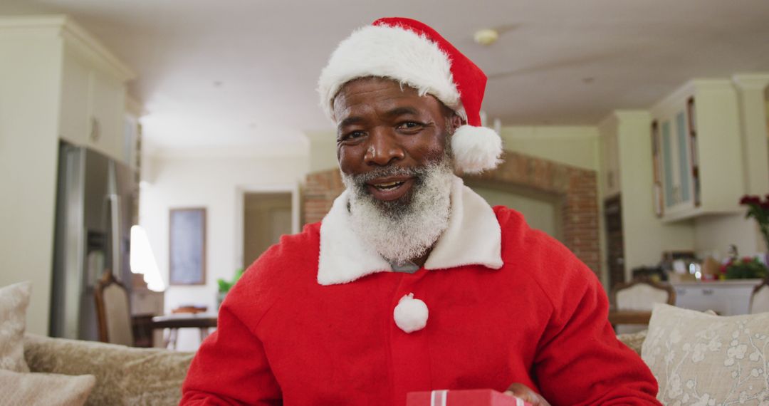 Smiling African American Santa Claus Giving Gift Indoors - Free Images, Stock Photos and Pictures on Pikwizard.com