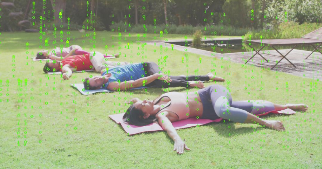 Group practicing restorative yoga on backyard lawn with mats near pond and wooden deck