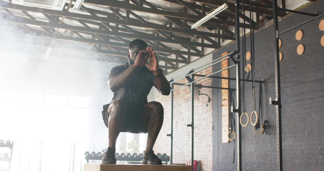 Man Performing Squats on Plyometric Box in Industrial Gym