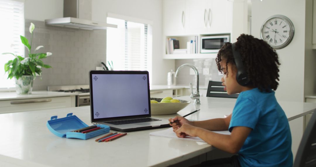 Young Boy Engaged in Online Learning at Modern Kitchen Table