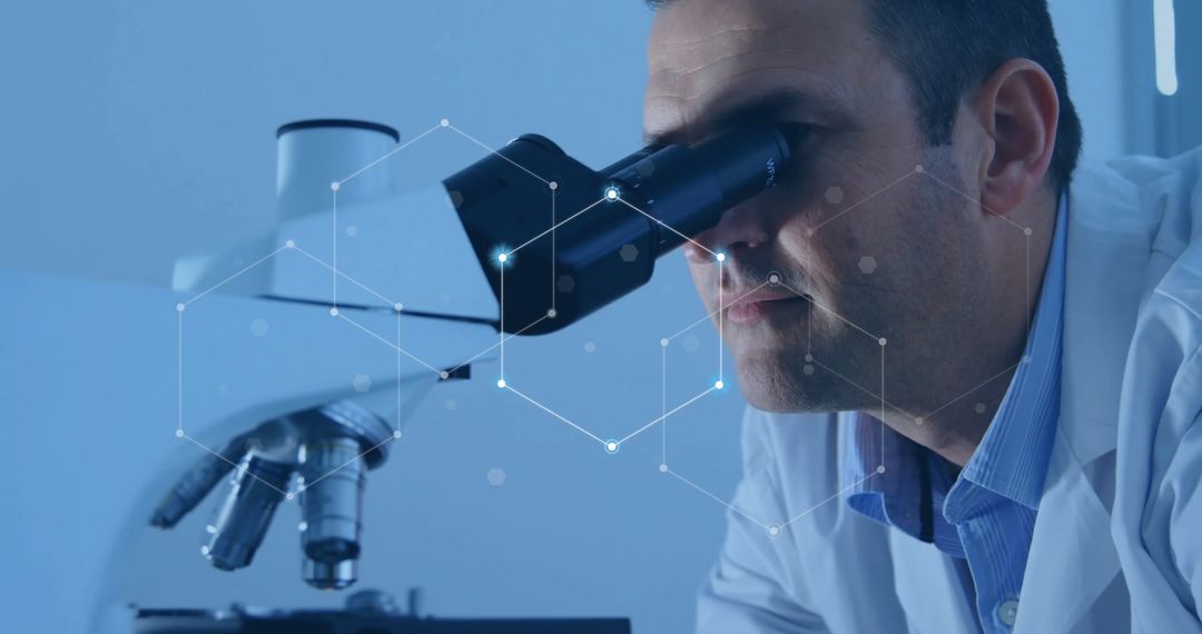 Male Scientist Observing Samples Through Microscope in Laboratory